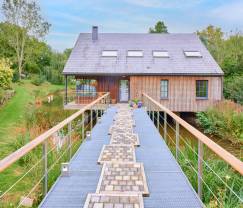 Charmant chalet sur pilotis, au bord de l'eau, pour 2 personnes à Ferrières avec poêle à bois, jardin et terrasse privée